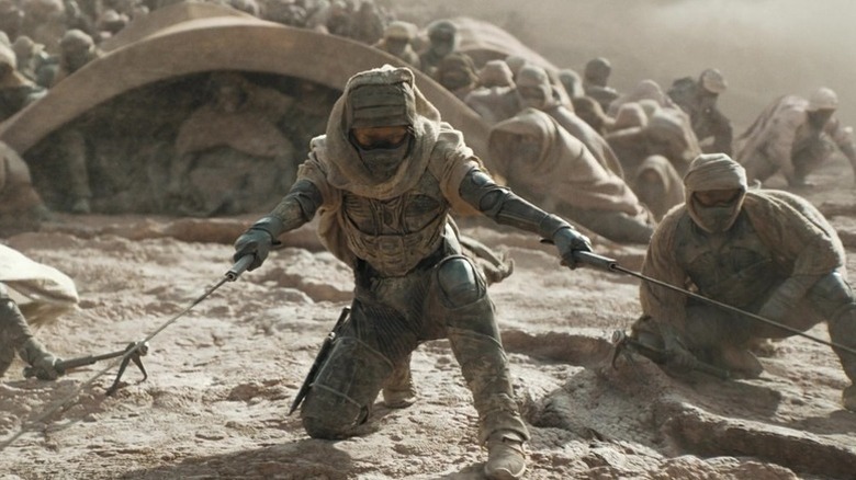 Fremen ride on a sandworm in "Dune: Part Two" (2024)