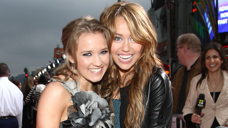 Miley Cyrus and Emily Osment posing