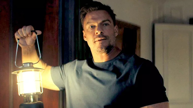 Jack Reacher holding up a lantern in "Reacher"