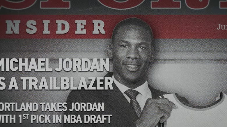 Michael Jordan holds a Trailblazers jersey