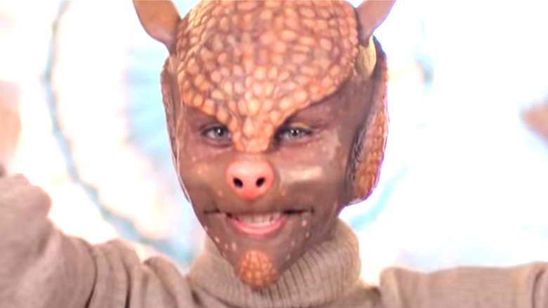 Person wearing prosthetic armadillo mask