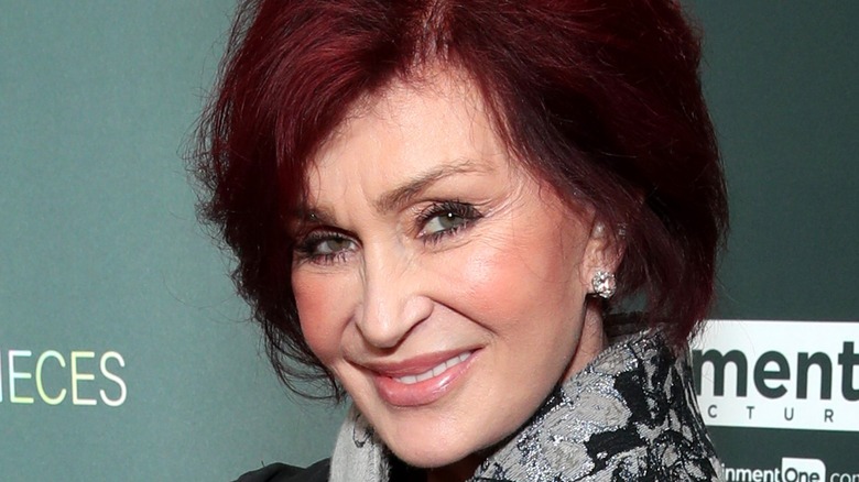 Sharon Osbourne smiling with earrings 