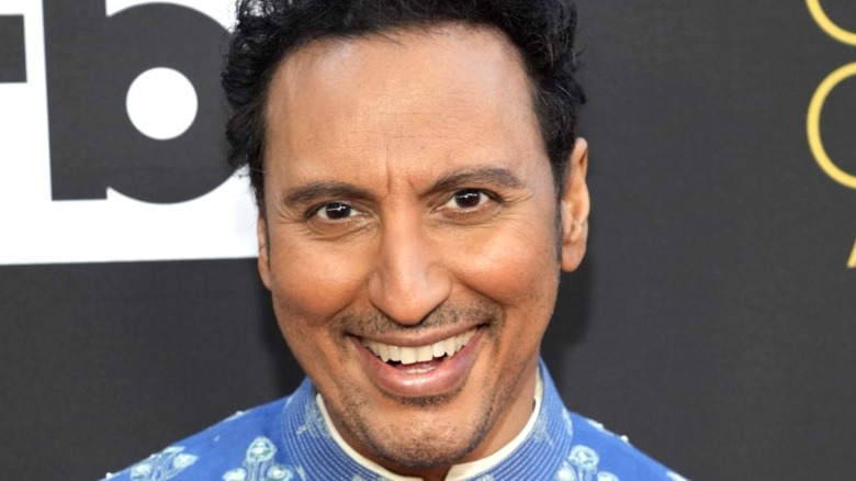Aasif Mandvi smiling at an event