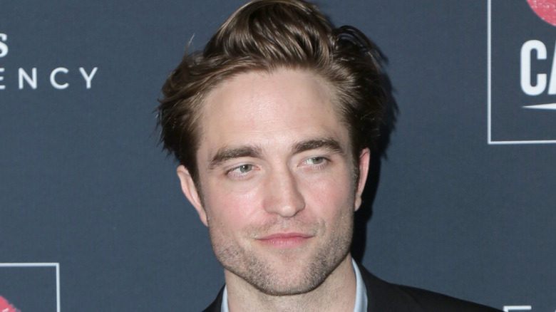 Robert Pattinson smiling at a premier
