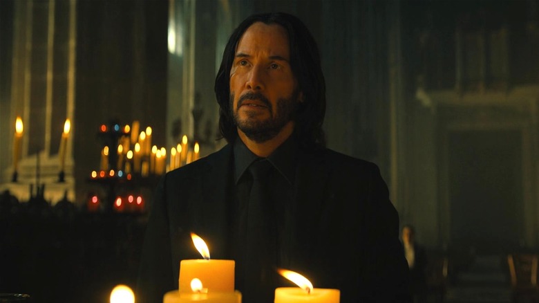 John Wick looking up by candles