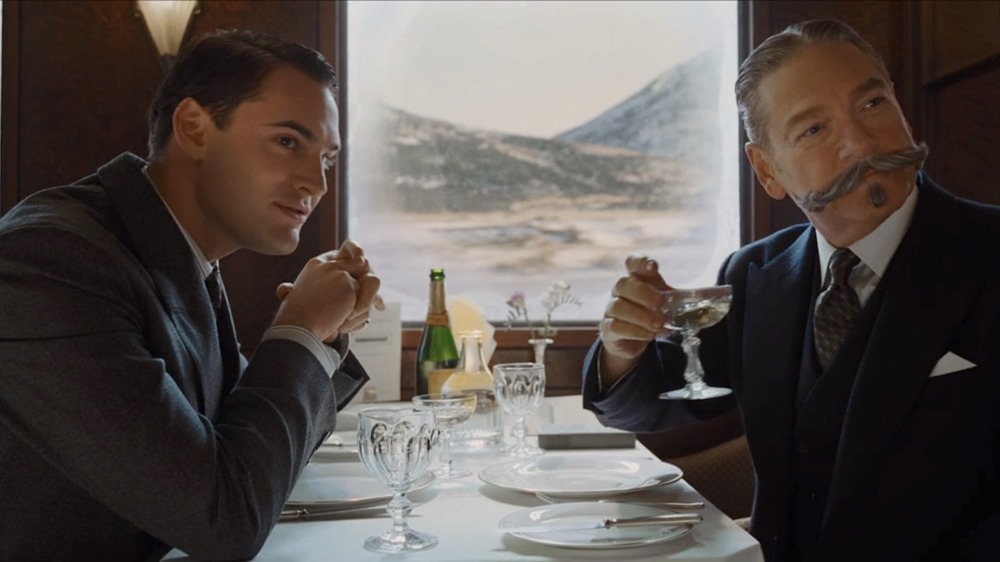 Bouc and Poirot seated on train in Murder on the Orient Express