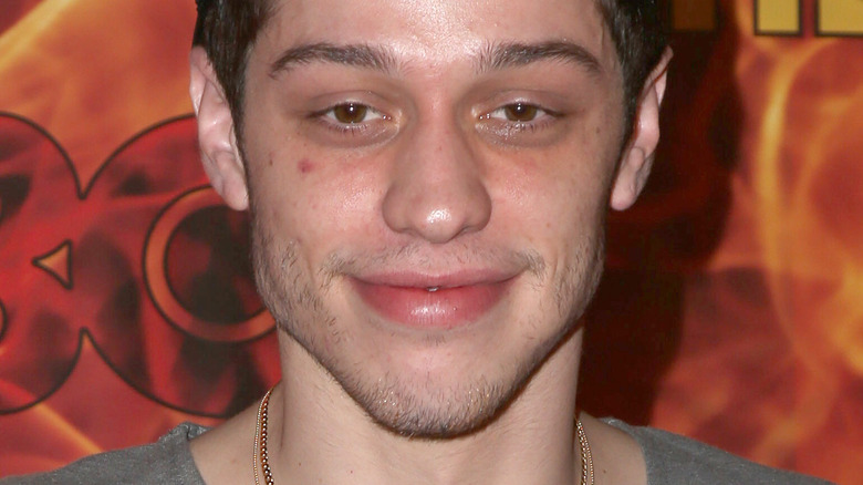 Pete Davidson half-smiling