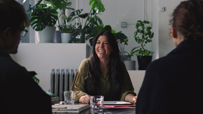 A wedding planner speaks to Charlie and Emma across a desk in "The Drama" (2026)