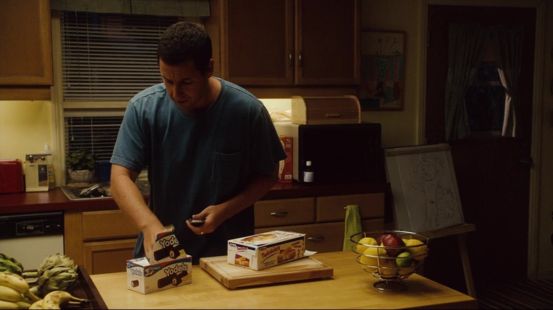   Adam Sandler agafa un Yodel d'una caixa a la cuina