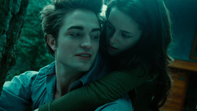 Edward carries Bella in forest