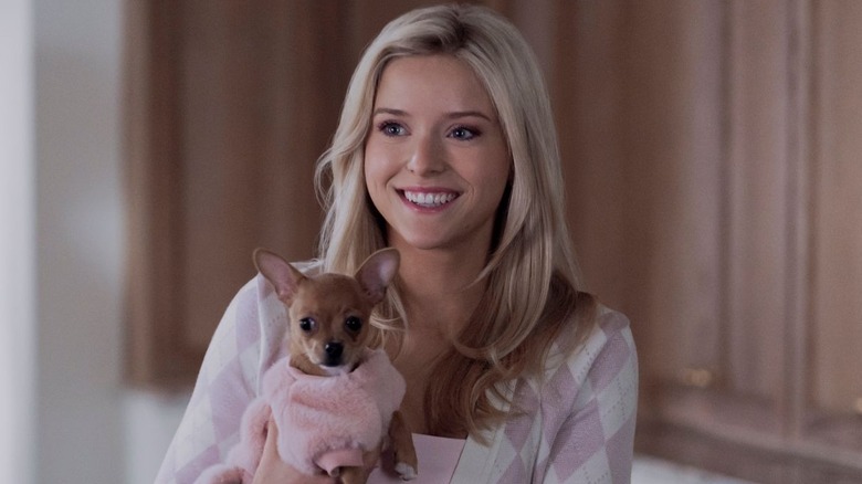 Elle stands while holding Bruiser in 