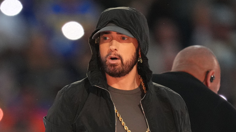 Eminem wearing a black hat and gold chain