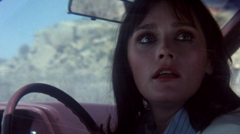 Margot Kidder looks over shoulder in car
