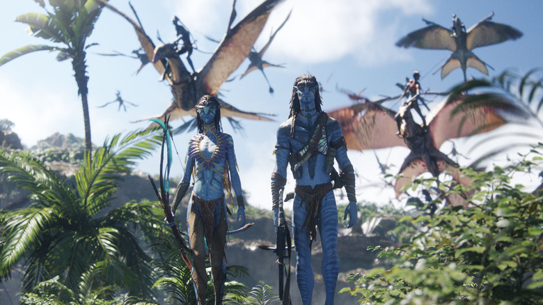 Jake and Neytiri walking while warriors fly in the background in Avatar: Fire and Ash