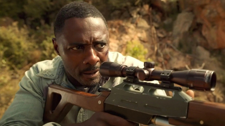   Idris Elba amb un rifle tranquil·litzant
