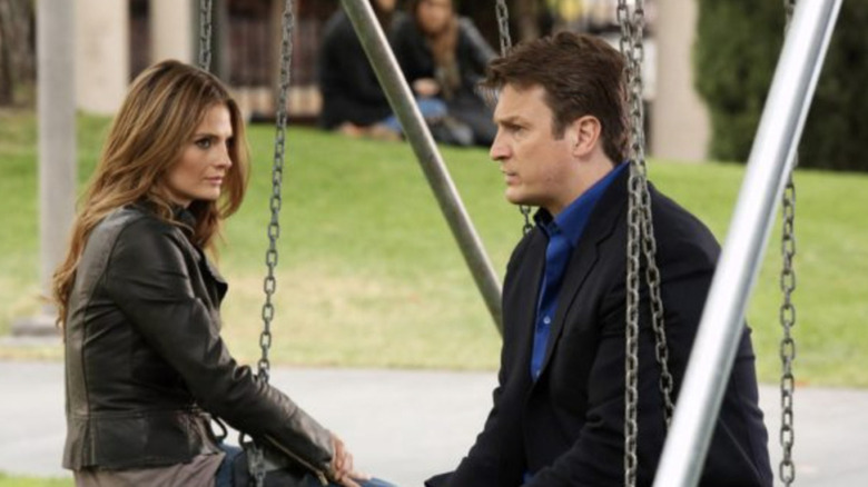 Castle and Beckett sit on swing set