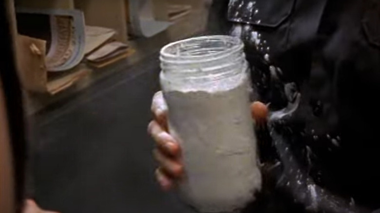 Man holding jar of powder