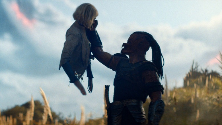 Dek holding up Thia in Predator: Badlands