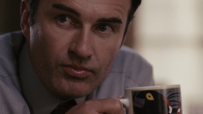 Jim Hanson looking up from his coffee mug in Premonition