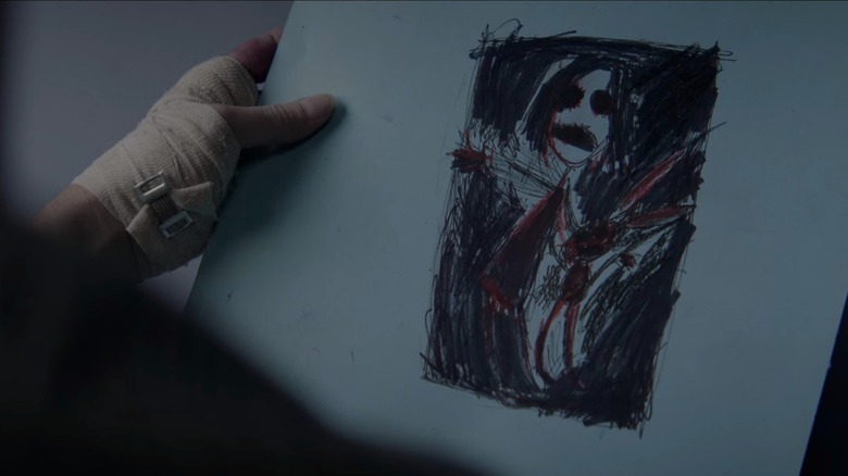 Someone holding Mia's creepy drawing