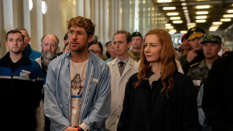 Ryland and Eva with scientists behind them in Project Hail Mary