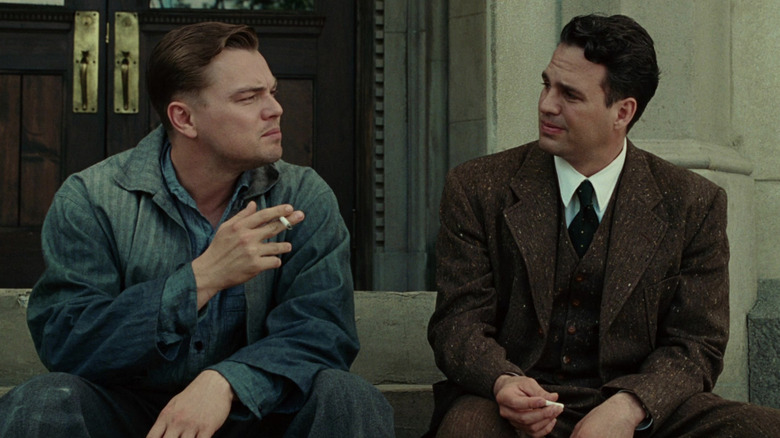 Teddy and Chuck sitting on steps outside and smoking together