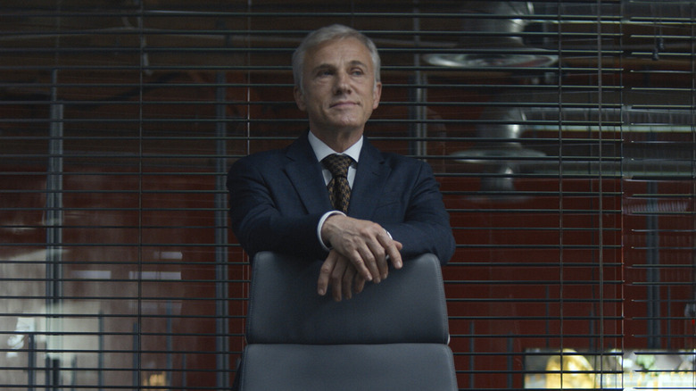 Patoff standing behind chair
