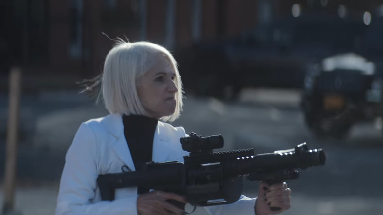 The Handler holds a grenade launcher