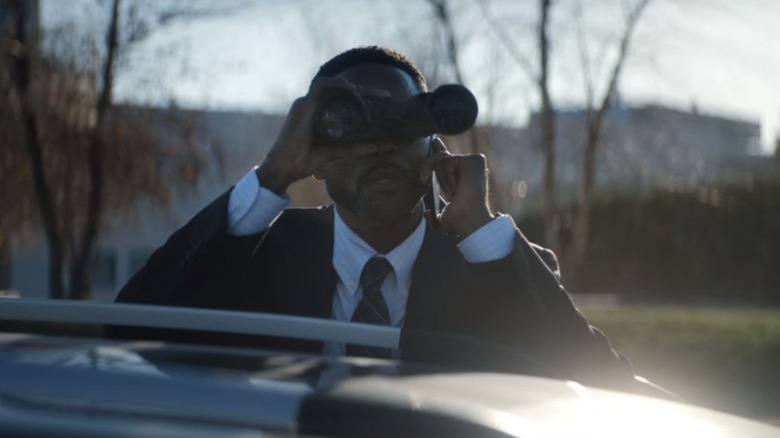 an FBI Agent looks through binoculars