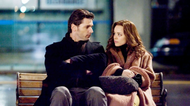 Henry and Clare sitting on a bench staring at each other