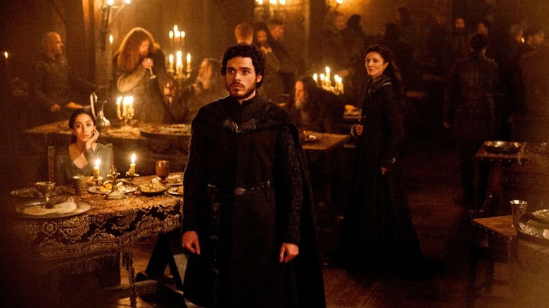 Robb standing shocked at the Red Wedding with Talisa and Catelyn behind him on Game of Thrones