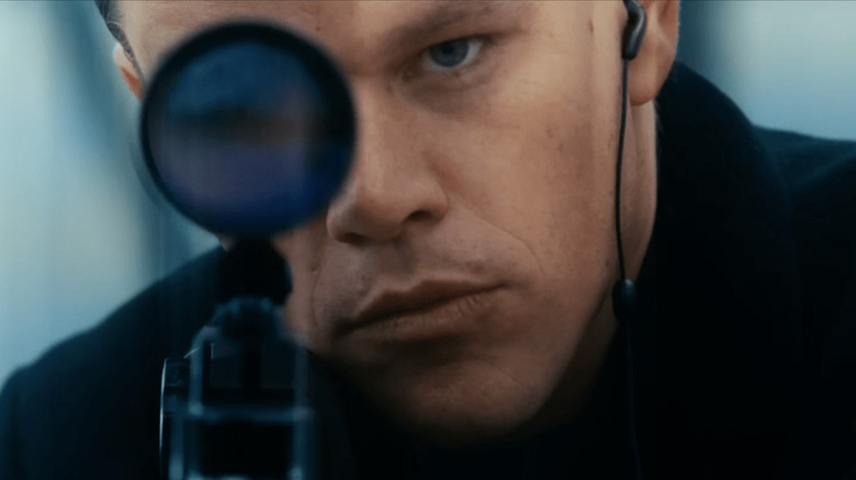 Jason Bourne looks through scope