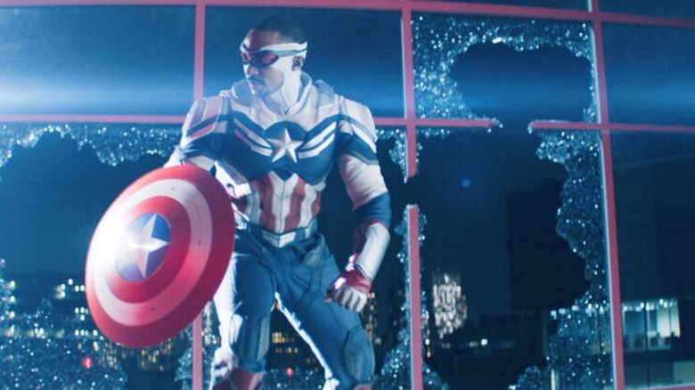 Sam Wilson as Captain America holding his shield near broken windows in "The Falcon and the Winter Soldier" (2021)