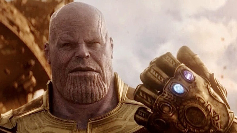 Thanos holds up the Infinity Gauntlet with two stones visible in "Avengers: Infinity War" (2018)
