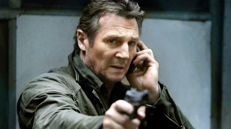 Liam Neeson points a gun