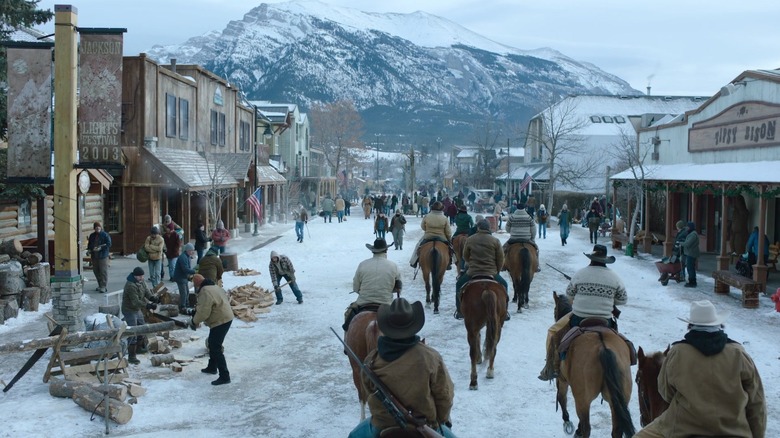 People riding horses into a snow-covered Jackson