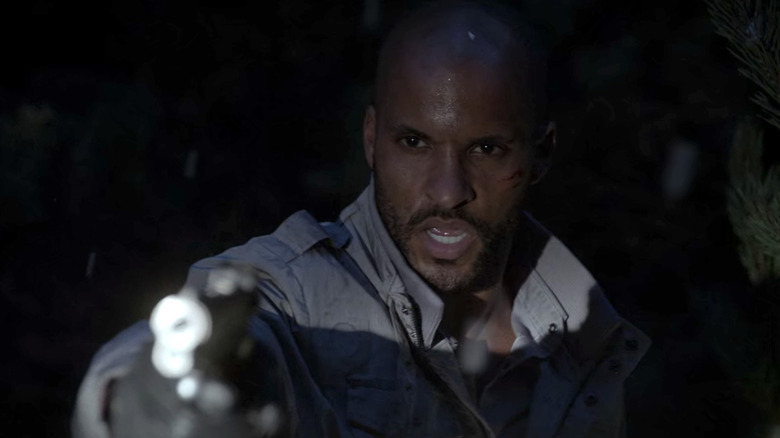 Ricky Whittle pointing a gun