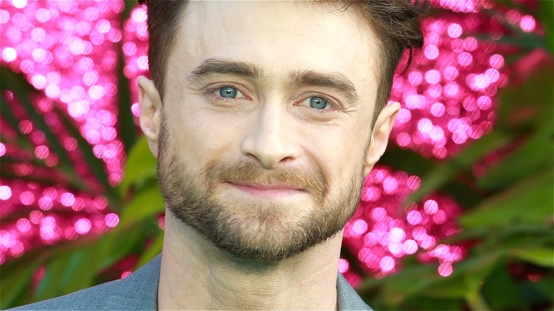 Daniel Radcliffe smiling in front of lights