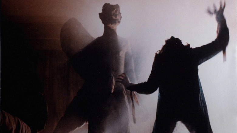 Regan reaches up with the demon Pazuzu behind her in "The Exorcist" (1973)