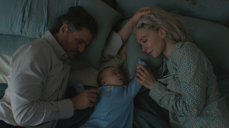 Reed Richards and Sue Storm lying next to Franklin Richards in The Fantastic Four: First Steps