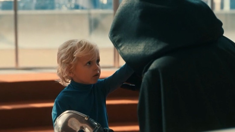 Franklin Richards reaching up to touch Doctor Doom's hidden face in The Fantastic Four: First Steps