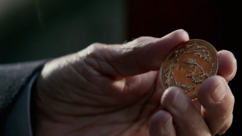 Hand holding a John Wick coin