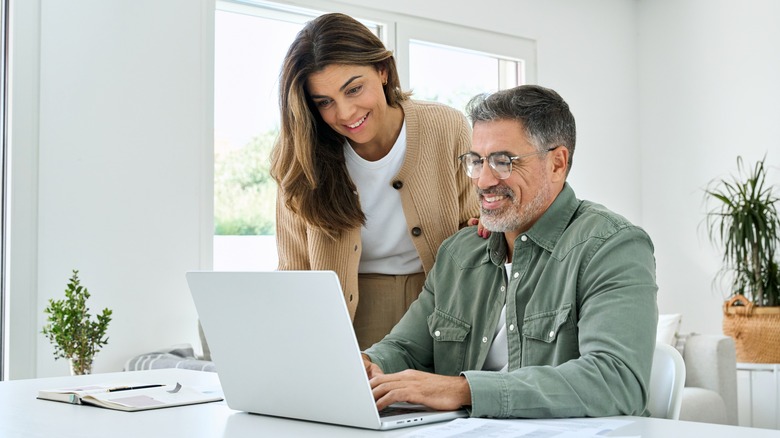 Couple looking at computer and smiling