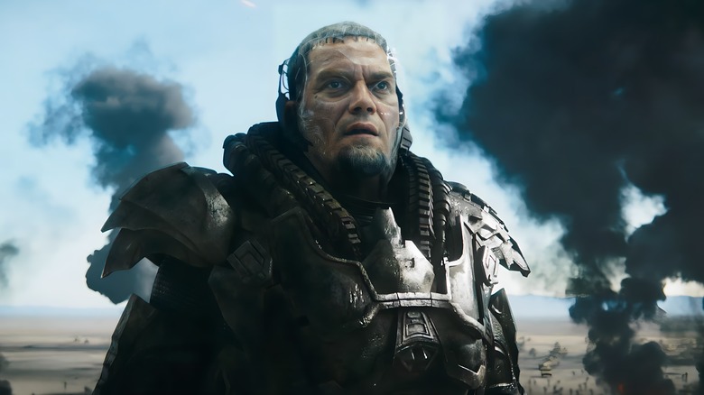 Zod in suit with black smoke behind