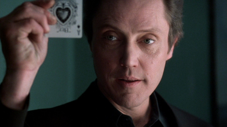 Frank White holds up a playing card in 