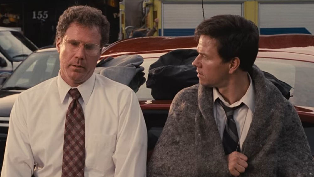 Will Ferrell and Mark Wahlberg sitting on car