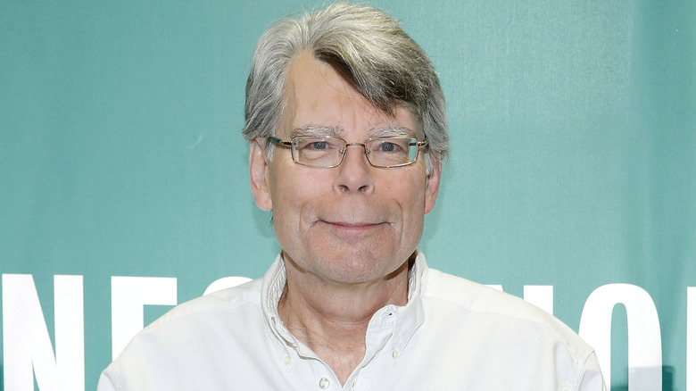Stephen King, in white chambray and glasses, smiling