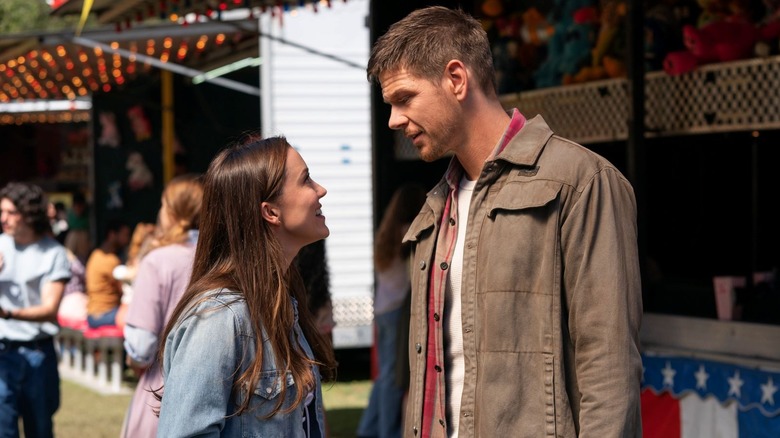 Jane Driscoll and Billy Pace look at each while at a carnival in Paradise (2025)