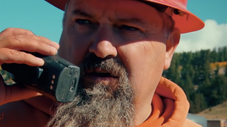 Todd Hoffman in orange hardhat, talking on radio