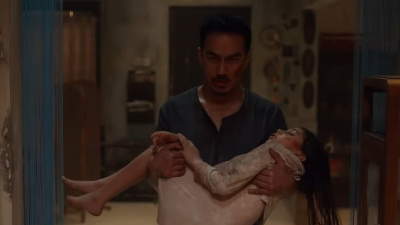 Joe Taslim holding child in The Night Comes for Us